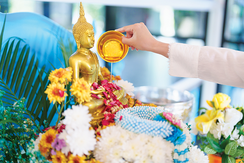 Sacred water is poured over Buddha statues 