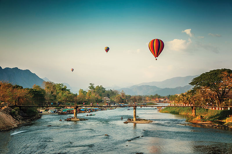 Hot-air balloons drift above the Nam Song River in Vang Vieng
